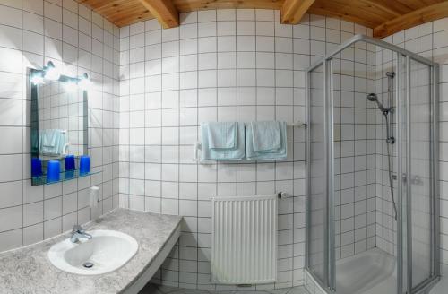 Kefermarkt葡萄园酿酒厂城堡 - 第一酿酒厂旅馆的白色瓷砖浴室设有水槽和淋浴