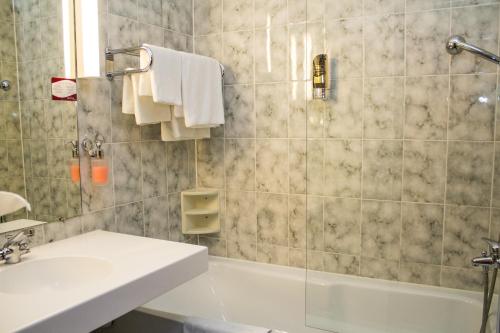 纽伦堡阿维娜百乐酒店的一间带水槽、浴缸和淋浴的浴室