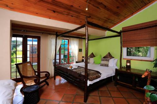斯泰伦博斯Orange-Ville Lodge & Guesthouse的一间卧室配有四柱床和椅子