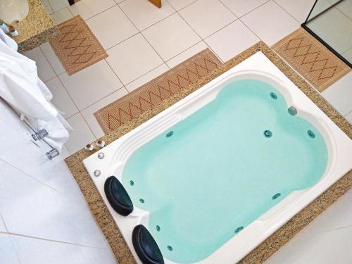 Resende CostaArraial da Lage Hospedaria的绿松石瓷砖浴室内的按摩浴缸