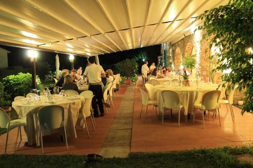 迪亚诺卡斯泰洛Villa Govi的一间设有白色桌椅的餐厅,晚上有人用餐