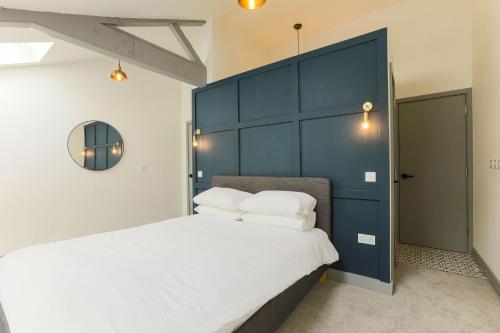 巴里Goodstay Apartments by Urban Space的一间卧室配有一张大床和蓝色床头板