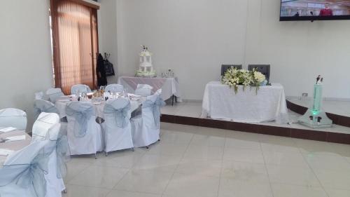 San José IturbideHotel SanJo的一间设有白色桌椅的房间,并拥有白色的鲜花
