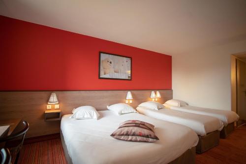 沙特尔沙特尔埃斯酒店的红色墙壁的房间里设有三张床