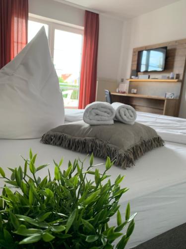 吉森吉森莱西登斯酒店的一间卧室配有带2条毛巾和植物的床