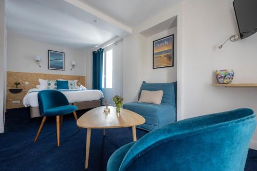拉罗谢尔Un Hotel sur le Port的酒店客房,配有一张床和两张蓝色椅子