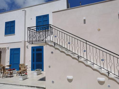 库斯托纳奇Cuore di Conchiglia的白色的建筑,设有蓝色百叶窗和楼梯