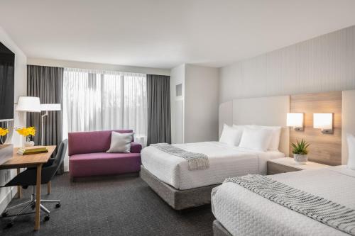 亚特兰大Crowne Plaza Atlanta Perimeter at Ravinia, an IHG Hotel的酒店客房设有两张床和一张紫色椅子