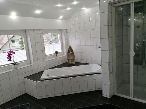丁克拉格Apartment Grieshop的白色瓷砖浴室设有浴缸和淋浴。