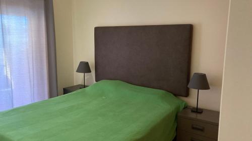 ConceiçãoFranciscos em Cabanas Golf的一间卧室配有一张带两盏灯的绿床。