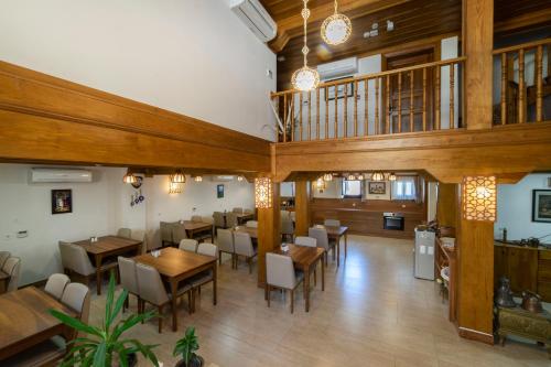 穆达尼亚阿尔米思提斯酒店的用餐室配有木桌和椅子