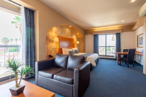 克雷塔罗火烈鸟酒店的酒店客房,配有床和沙发