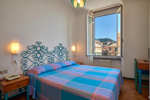 菲纳莱利古雷Hotel Garibaldi的一间卧室设有一张大床和一个窗户。