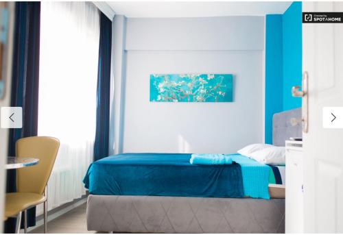伊斯坦布尔Blue Apartments的一间卧室配有蓝色的床和椅子
