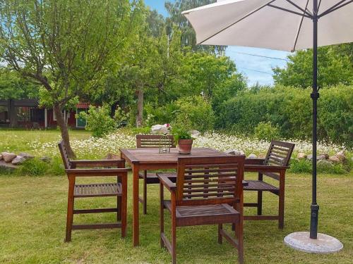 Stenhamra4 person holiday home in STENHAMRA的一张带椅子的木桌和一把伞