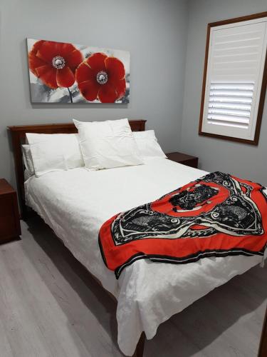 凯阿玛Never Inn的卧室配有一张挂着红色鲜花的床。