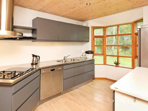 莱斯6 person holiday home in L s的厨房配有不锈钢用具和木制天花板。