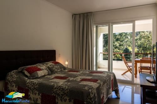 埃斯特角城Green Park Propietarios的一间卧室设有一张床和一个阳台