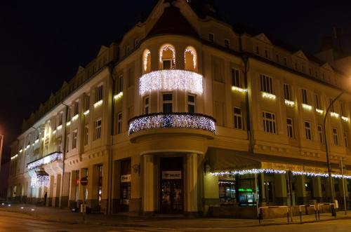 考波什堡Hotel Dorottya的建筑的侧面有圣诞灯