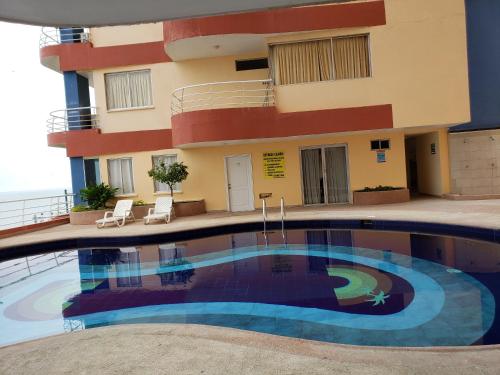 阿塔卡梅斯Arco Iris Atacames的大楼前设有游泳池的酒店