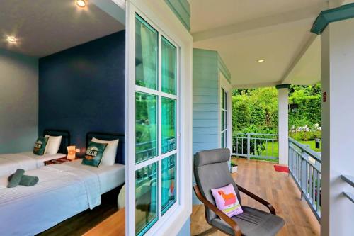 尖竹汶Little Cottage的一间卧室设有配有两张床和椅子的阳台