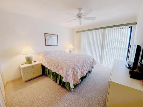 大洋城Ocean Princess 207的一间卧室配有一张床、梳妆台和电视。