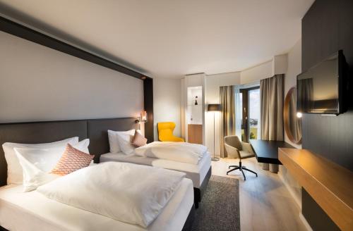 诺伊斯Crowne Plaza Düsseldorf - Neuss, ein IHG Hotel的酒店客房设有两张床和电视。