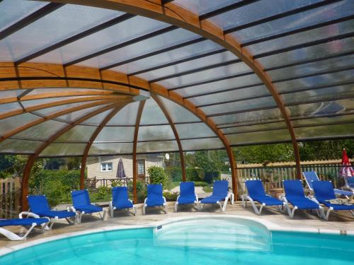 Licques苹果三个国家露营酒店的一个带椅子的凉亭和一个游泳池