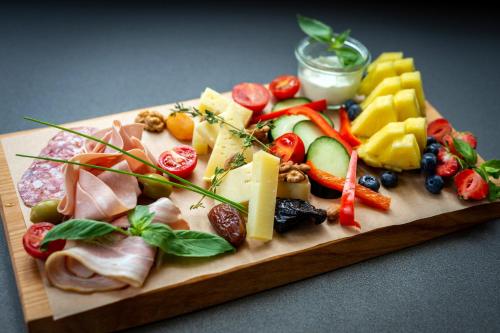 卢布尔雅那Hotel Mrak Superior的一块食物,包括奶酪、水果和蔬菜
