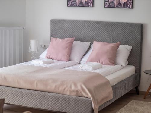 艾杰克Völgy Vendégház的床上配有粉色和白色枕头的床