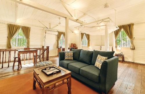 珍南海滩Temple Tree Resort的客厅配有绿色沙发和桌子