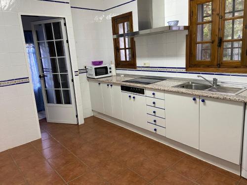 ArgésChalet 300m con 1000m parcela privada a 5min de Puy Du Fou的厨房配有白色橱柜、水槽和微波炉