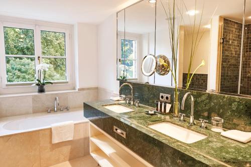 柯尼希斯温特Steigenberger Grandhotel & Spa Petersberg的一间带两个盥洗盆和大镜子的浴室