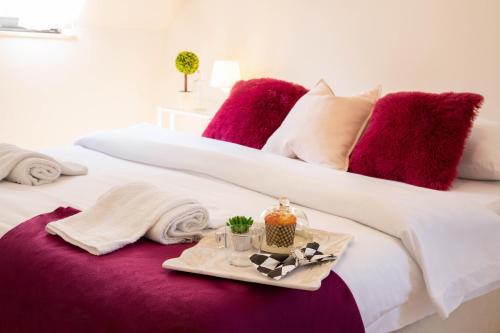 萨格勒布Rooms 88的一张带紫色枕头的床和一个带蜡烛的托盘