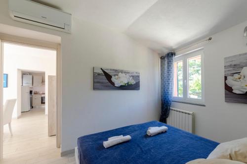 拉帕洛CASA ROSA- Appartamento nel verde con posto auto, zona tranquilla,wifi gratuito,aria condizionata的一间卧室配有蓝色的床和2条毛巾