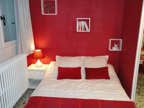 GagnyStudio Framboise proche Paris et Disneyland的红色卧室配有带2个红色枕头的床
