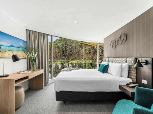 悉尼悉尼码头套房大酒店的配有一张床和一张书桌的酒店客房