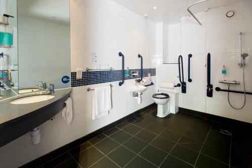 利兹利兹市中心军械库智选假日酒店的浴室设有2个水槽、卫生间和镜子。