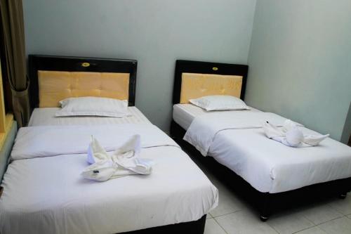 万加普Pondok Wisata dan Restoran Elim的两张带白色面罩的床