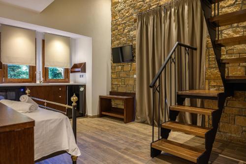 欧拉努波利斯Arxontariki Suites的客房设有一张床和带电视的楼梯。