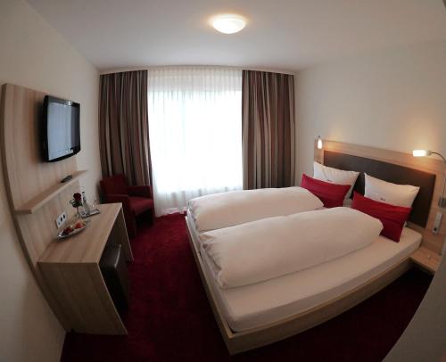 韦因斯塔特Gästehaus Rössle的酒店客房设有两张床和电视。