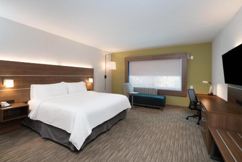 亚特兰大Holiday Inn Express & Suites Atlanta Airport NE - Hapeville, an IHG Hotel的酒店客房,配有床和电视