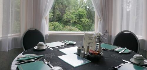 普雷斯顿阿什伍德酒店的餐桌、椅子和大窗户