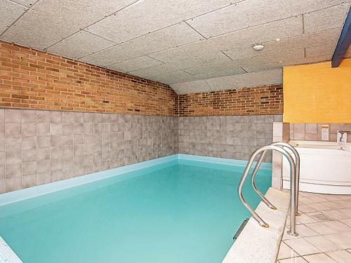 灵克宾7 person holiday home in Ringk bing的砖墙房间的游泳池