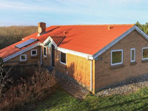 灵克宾7 person holiday home in Ringk bing的一座带橙色屋顶的小砖屋