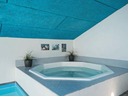 埃贝尔托夫特10 person holiday home in Ebeltoft的蓝色天花板的大浴缸
