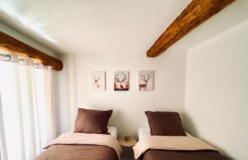 Saint-Dalmas-le-SelvageRésidence Saint-Jean的配有白色墙壁和木梁的客房内的两张床