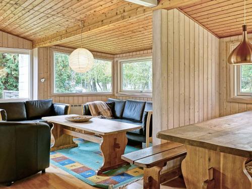 维斯特索马肯6 person holiday home in Aakirkeby的客厅配有木桌和椅子