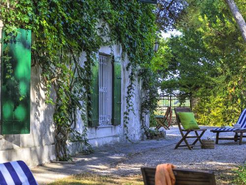 西尼加利亚Belvilla by OYO Monti的一个带椅子的院子和一座藤蔓建筑