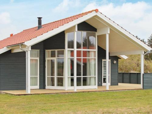 法贾德嘉德8 person holiday home in Ulfborg的甲板上设有大窗户的房子